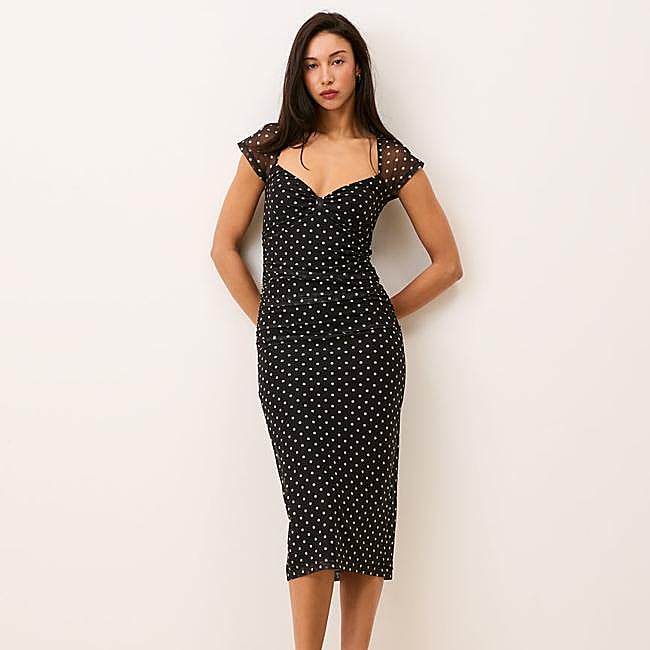 Vestido midi negro de lunares de Rouje, 185 euros.