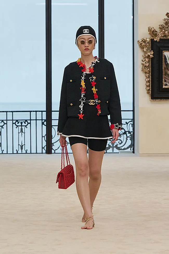 Runway of Chanel's Cruise 2027 collection with sole-less sandals in gold.