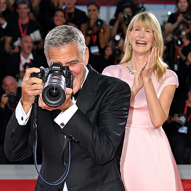 George Clooney jokes with a camera next to Laura Dern.