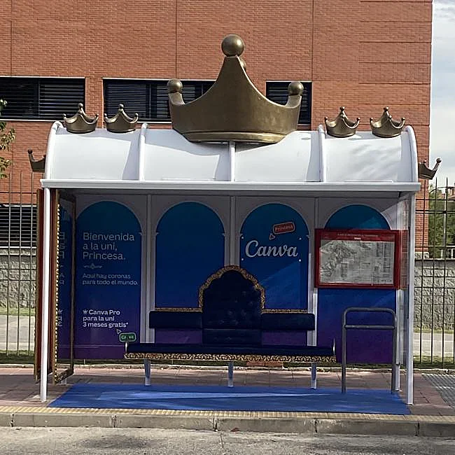 Parada de autobús frente a la Facultad de Ciencias Sociales y Jurídicas de la Universidad Caarlos III de Madrid, en Getafe, con el anuncio de Canva con motivo del inicio de curso universitario de la princesa Leonor