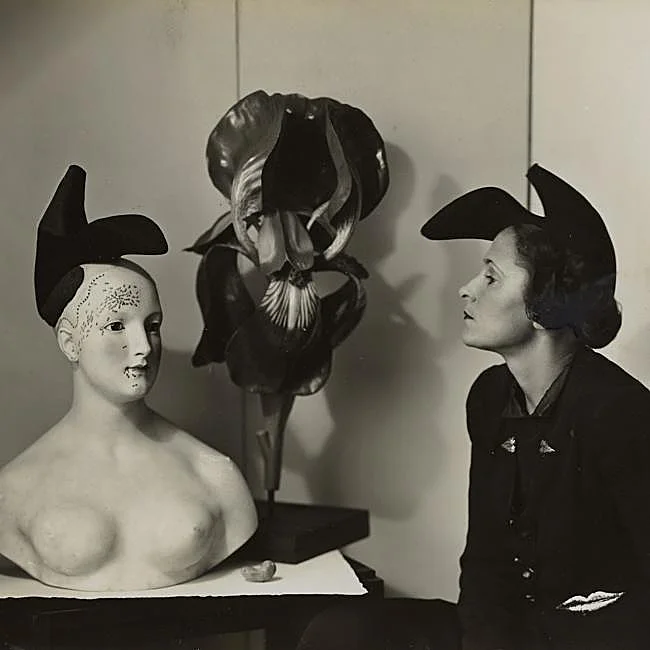 Gala, photographed by André Caillet in 1938, wearing Elsa Schiaparelli's shoe-hat inspired by a Salvador Dalí design.